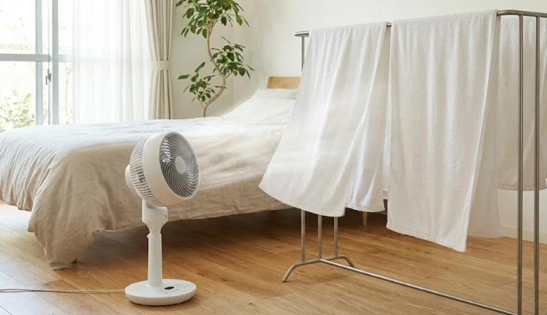 寝室でハンガーに干した濡れタオルにサーキュレーターの風を当てて、強制的に気化させている様子。